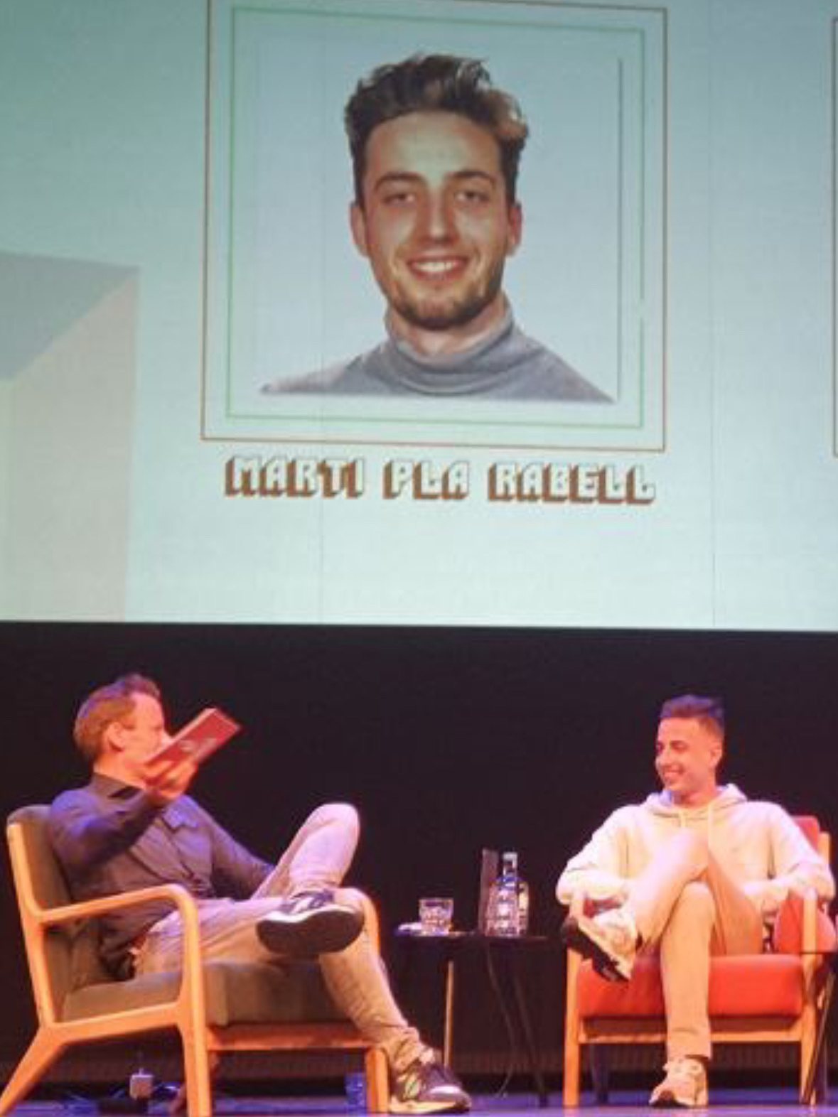 Marti en el escenario de la Dutch Blockchain Week, con su nombre en la pantalla