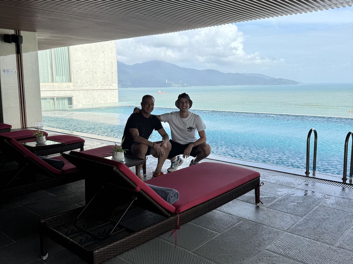 Marti y su padre junto a una piscina con vistas al mar en Vietnam